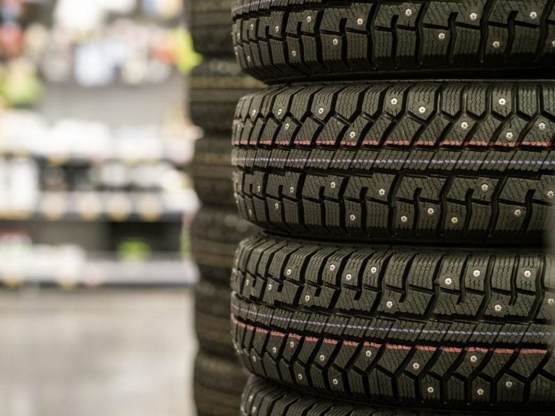 Sale of car tires for sale in the store. Many new winter tires lie horizontally. There is space for text